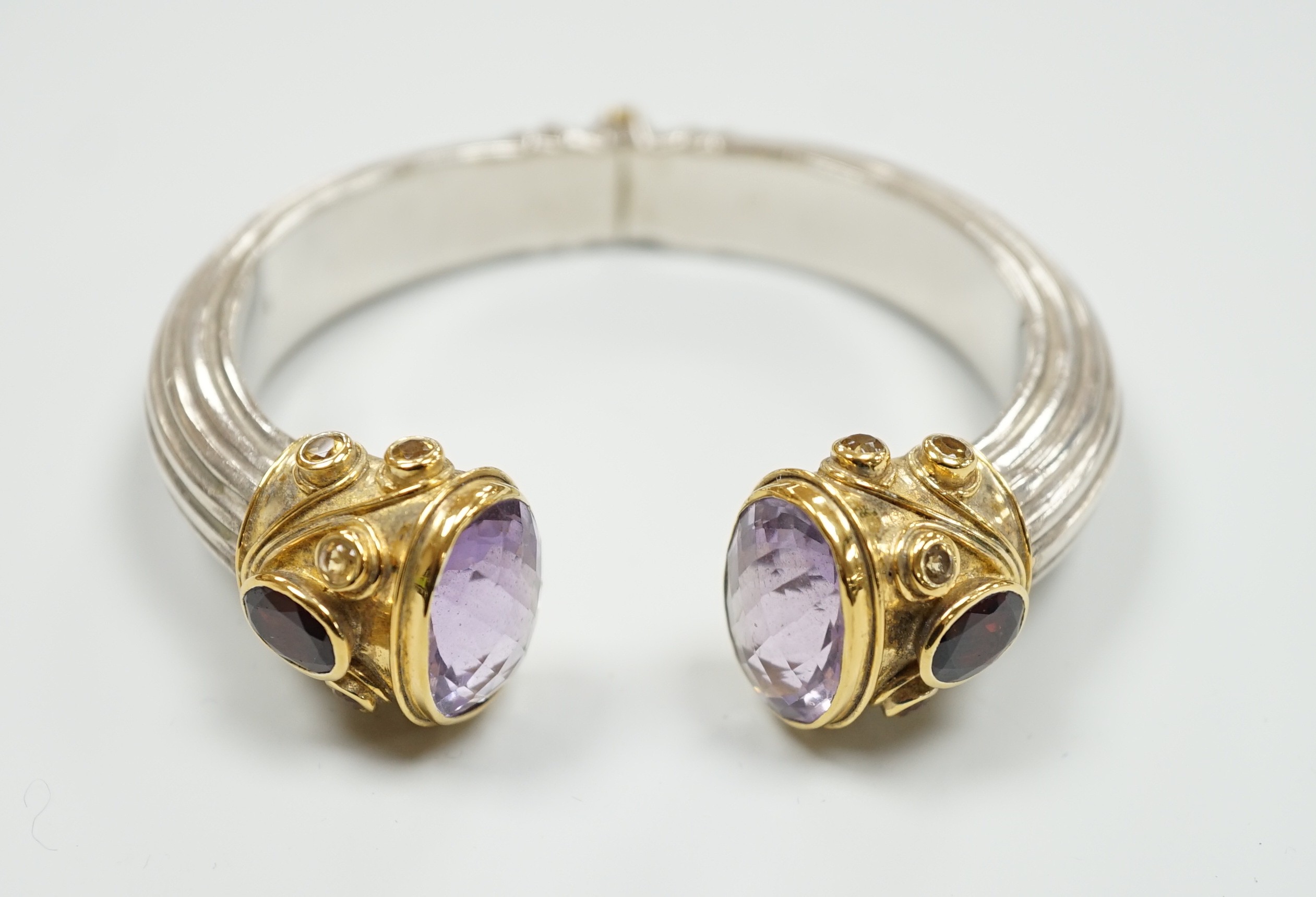 A modern parcel gilt silver amethyst and citrine set openwork spring hinged bangle.